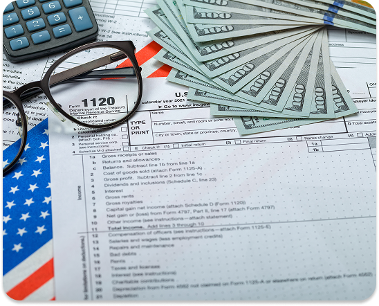 Tax forms with Money on top of them and a pair of glasses.